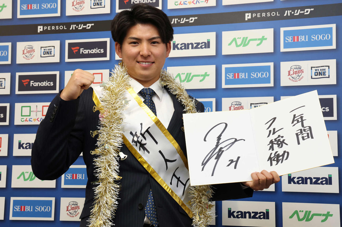「一年間フル稼働」と、来季の目標を記した色紙を手にポーズを決める西武武内（撮影・丹羽敏通）