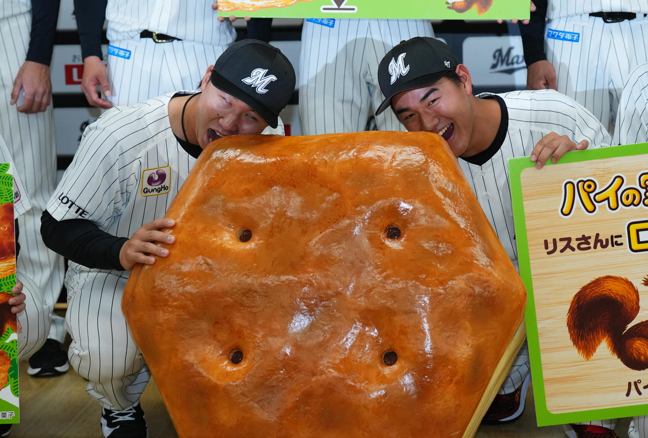 2024年度ロッテ新入団選手発表会で大きなパイの実にかぶりつく宮崎（左）と西川（撮影・菅敏）