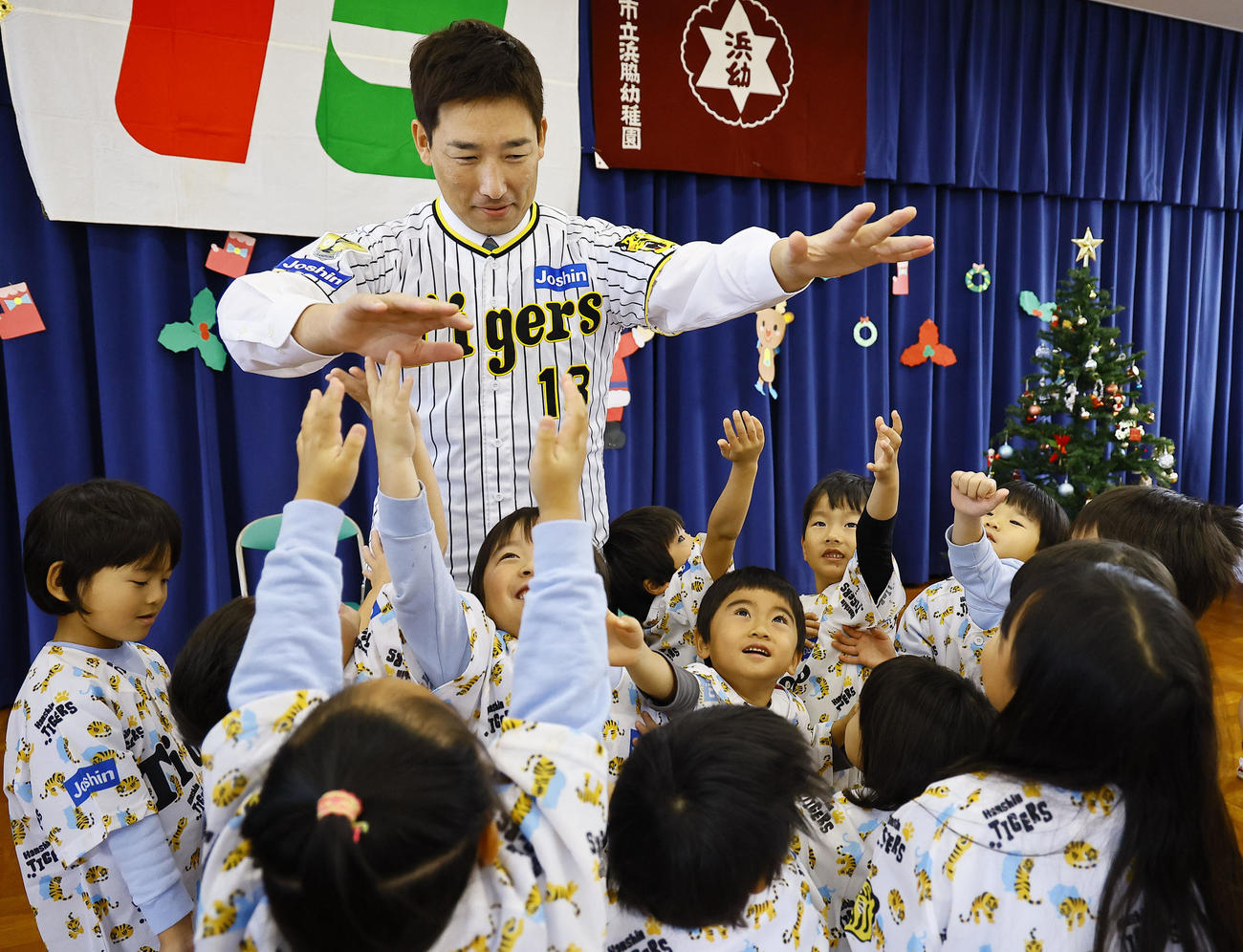 玩具を寄贈し、園児とタッチを交わす阪神岩崎（撮影・藤尾明華）
