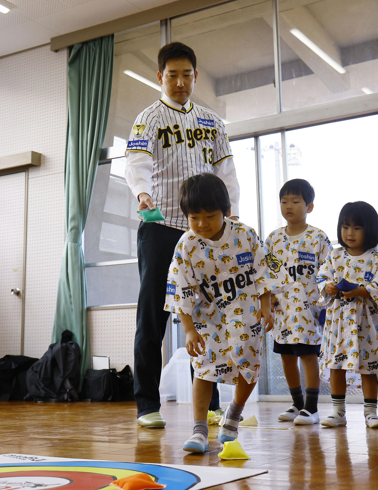 玩具を寄贈し、子どもたちと一緒に遊ぶ阪神岩崎（撮影・藤尾明華）