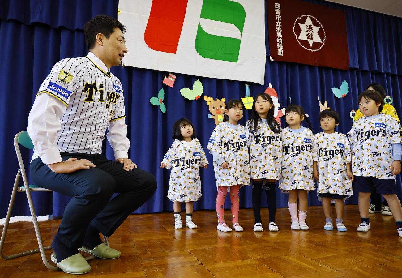 玩具を寄贈し、園児からのお礼の歌を聞く阪神岩崎（左端）（撮影・藤尾明華）