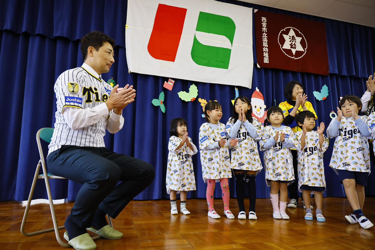 玩具を寄贈し、園児からのお礼の歌を聞く阪神岩崎（左端）（撮影・藤尾明華）