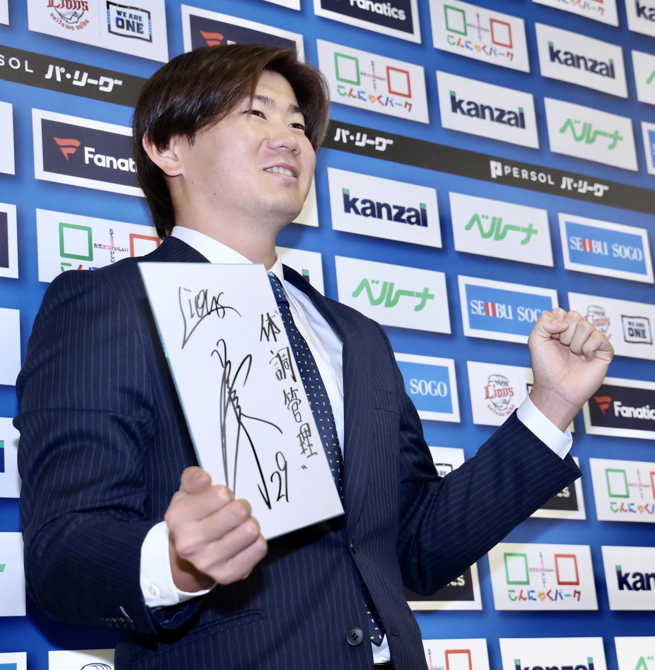 来季の目標を記し、笑顔で写真に納まる西武青山（撮影・河田真司）