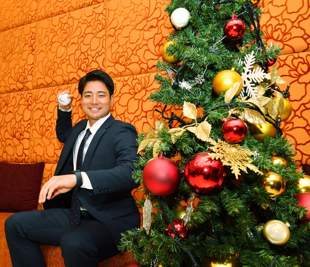 仮契約を終えクリスマスツリーの前で笑顔をみせる中日ドラフト4位の石伊（撮影・清水貴仁）