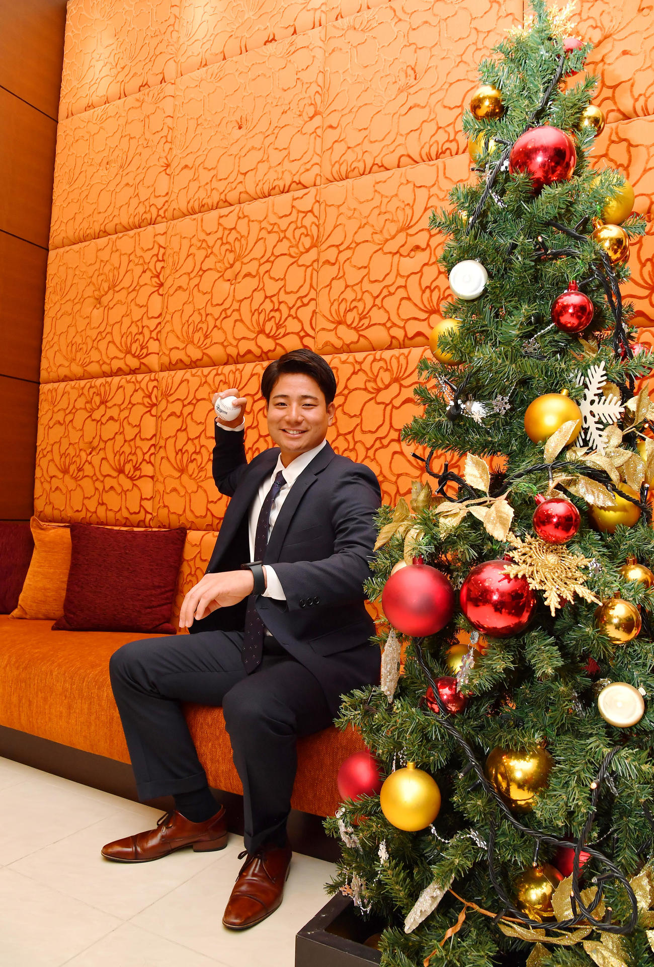 仮契約を終えクリスマスツリーの前で笑顔をみせる中日ドラフト4位の石伊（撮影・清水貴仁）