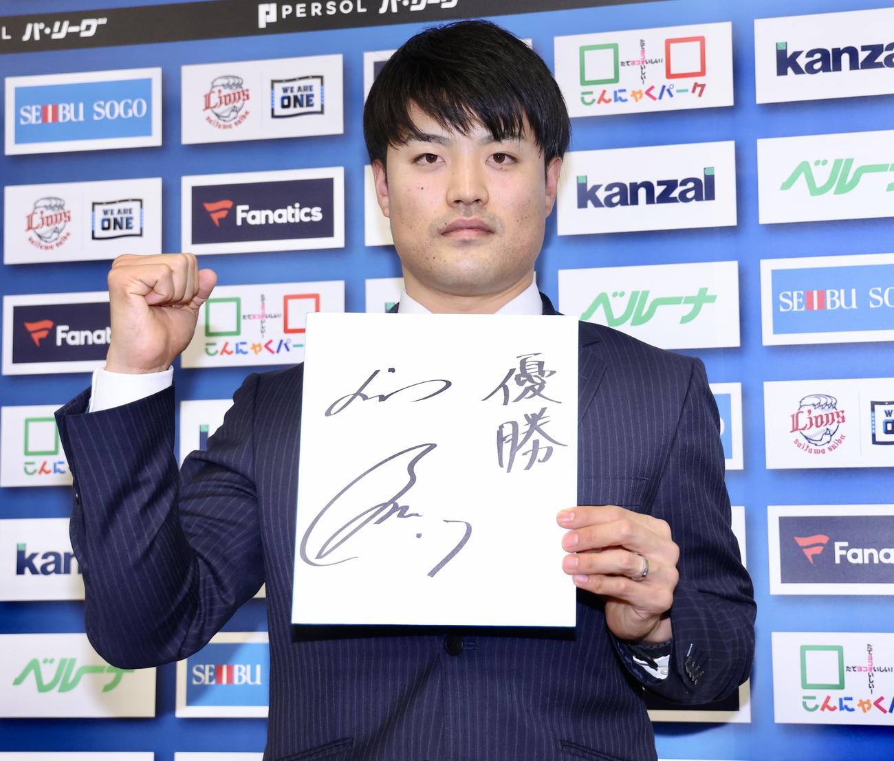 来季の目標を記し、写真に納まる西武松本（撮影・河田真司）