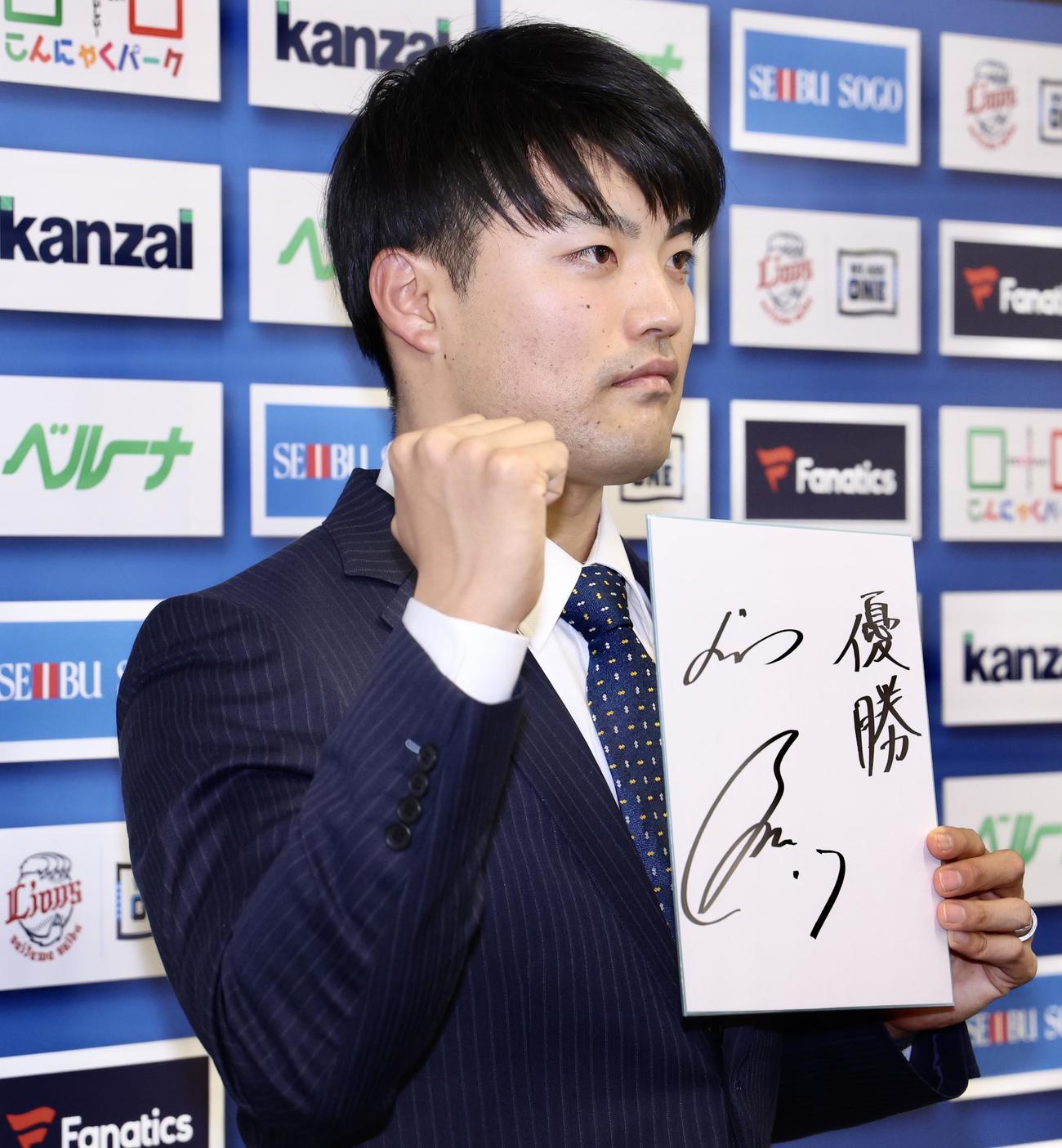 来季の目標を記し、写真に納まる西武松本（撮影・河田真司）