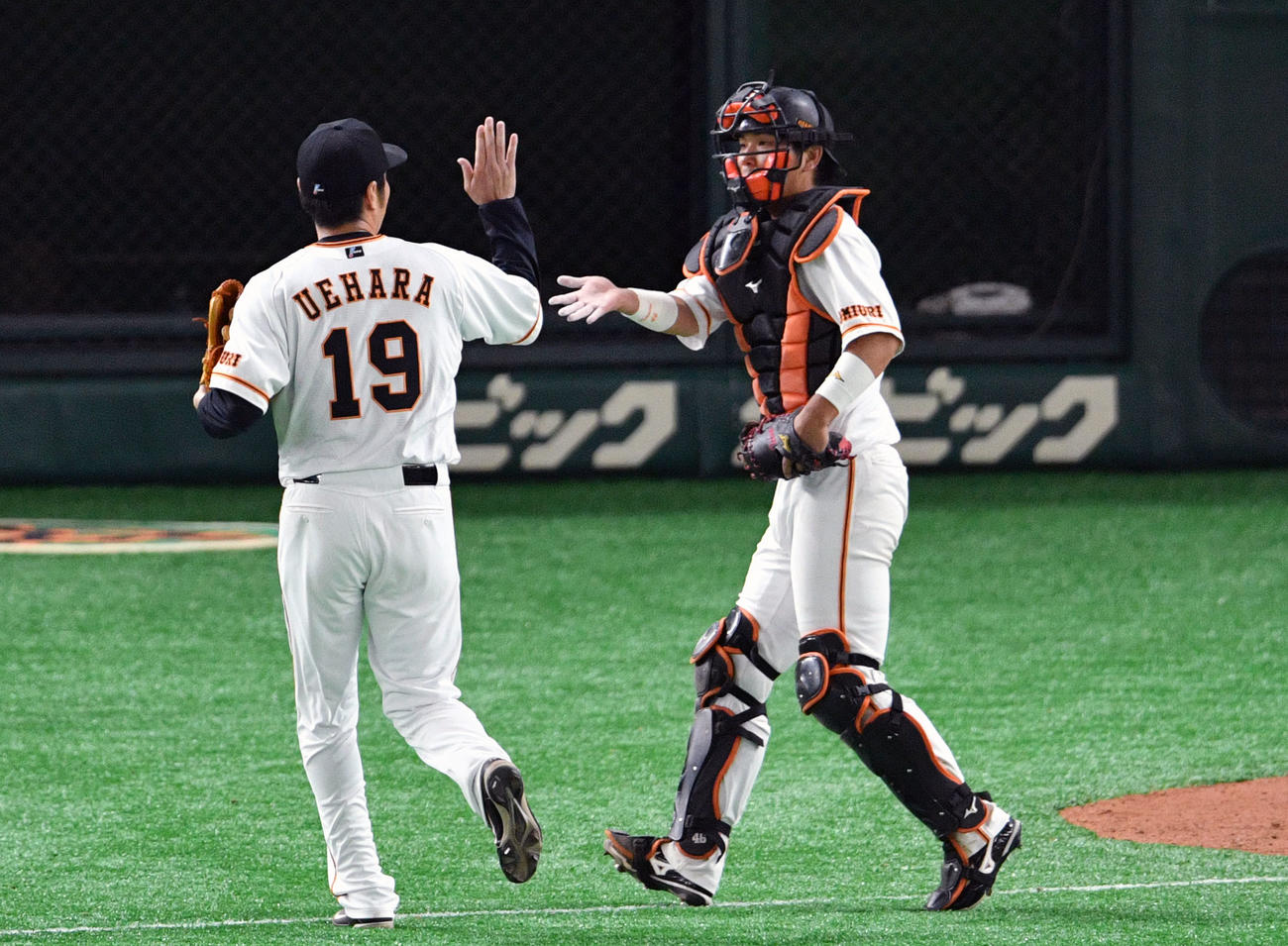 巨人上原（左）は大城とタッチを交わす（2019年3月撮影）