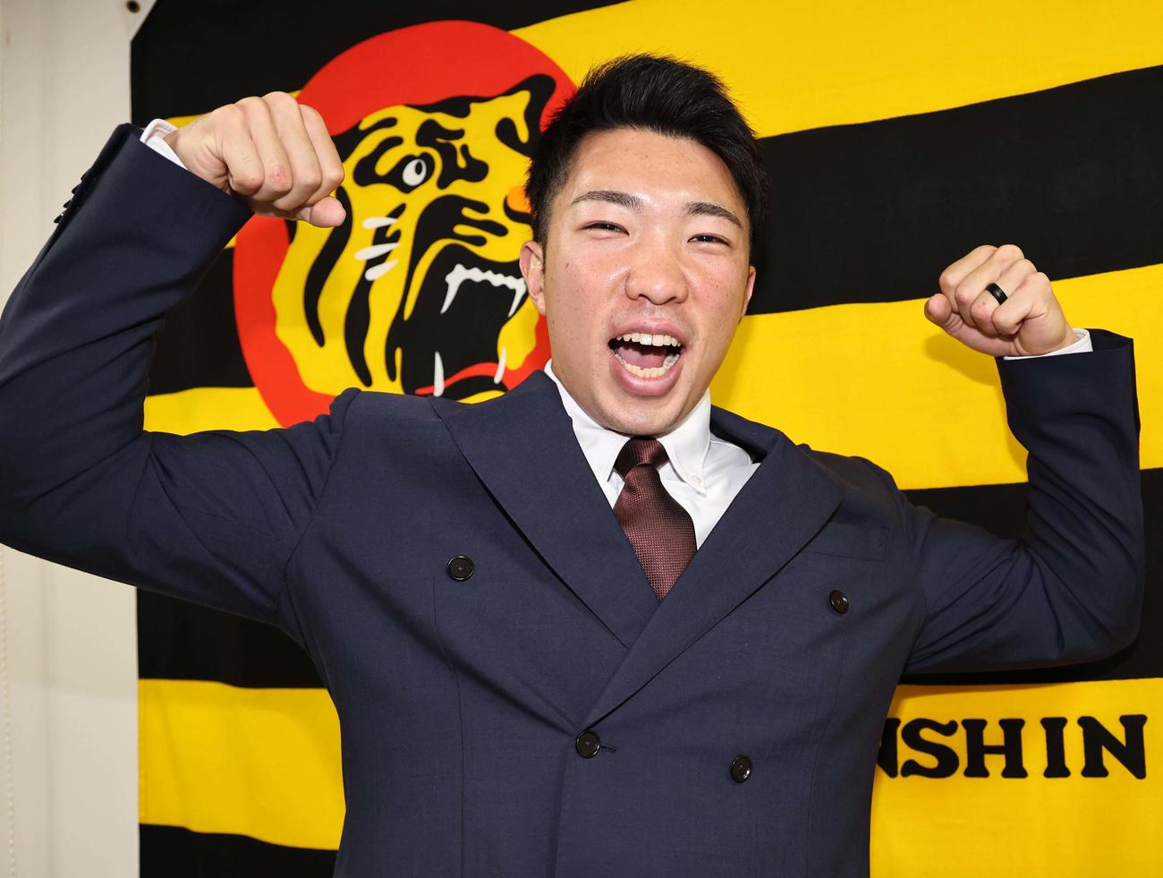 契約更改を終えた石井はマッスルポーズで笑顔を見せる（撮影・上田博志）
