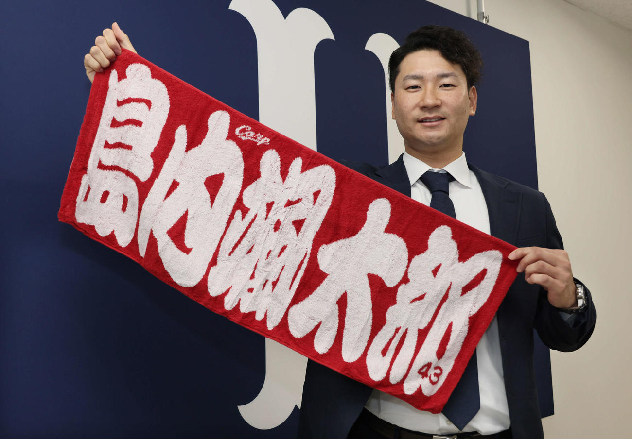 契約更改後の会見を終え、昨年の要望で実現した「島内グッズ」のタオルを手に笑顔を見せる広島島内（撮影・加藤孝規）
