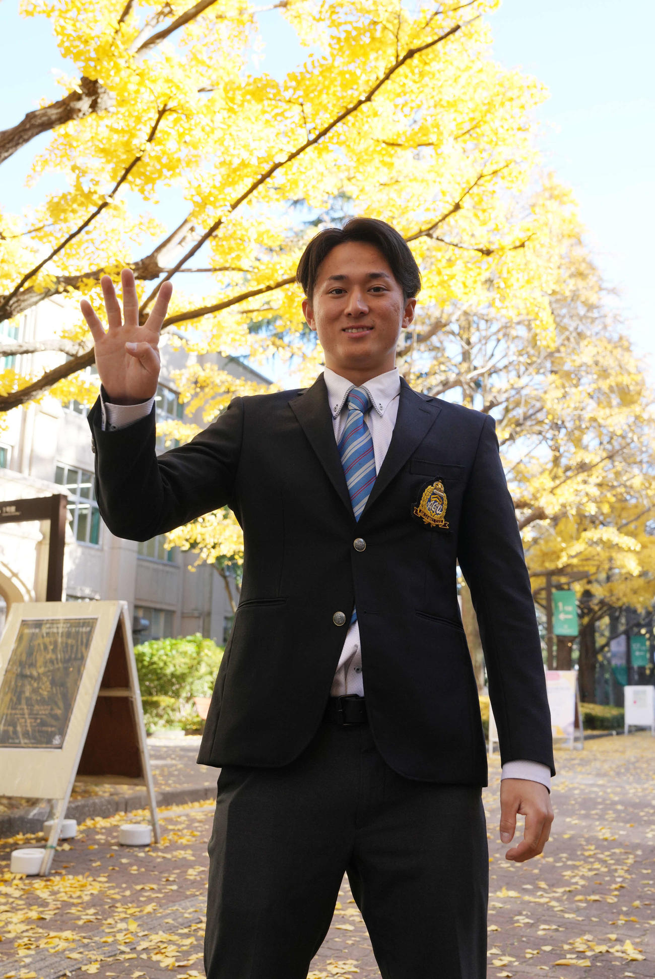 青学大の明治神宮大会優勝報告会に臨み年度チーム4冠の「4」のポーズで笑顔を見せる広島1位指名の佐々木（撮影・小沢裕）