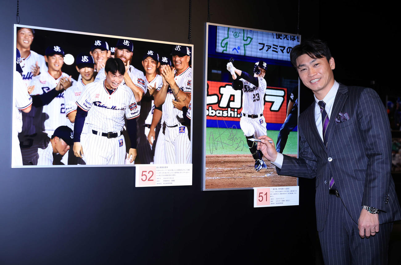 「野球報道写真展2024」のゲストで訪れた青木宣親氏は、自身の写真にサインを入れて笑顔（撮影・浅見桂子）