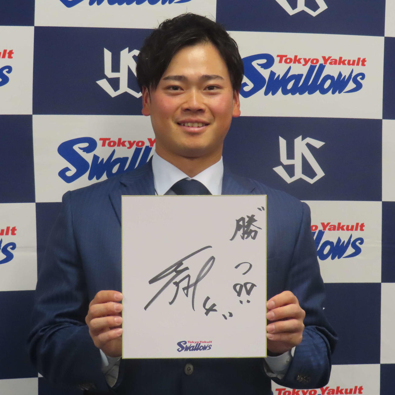 契約更改後の会見で、来季の目標を「勝つ」と色紙に記すヤクルト丸山和（撮影・水谷京裕）