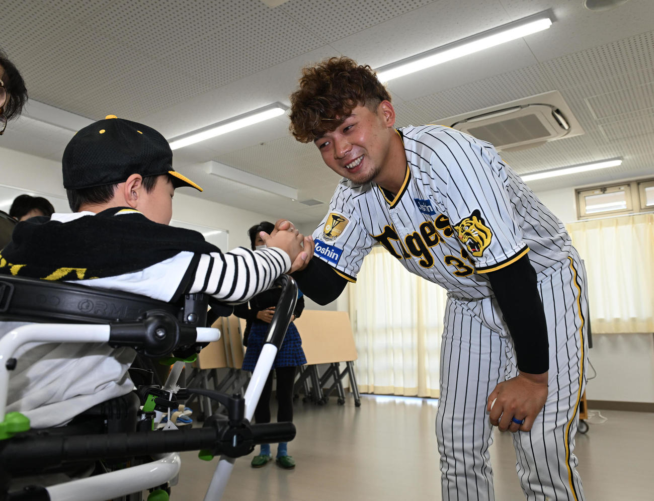 西宮支援学校を訪れ、生徒とハイタッチする阪神井上（撮影・和賀正仁）