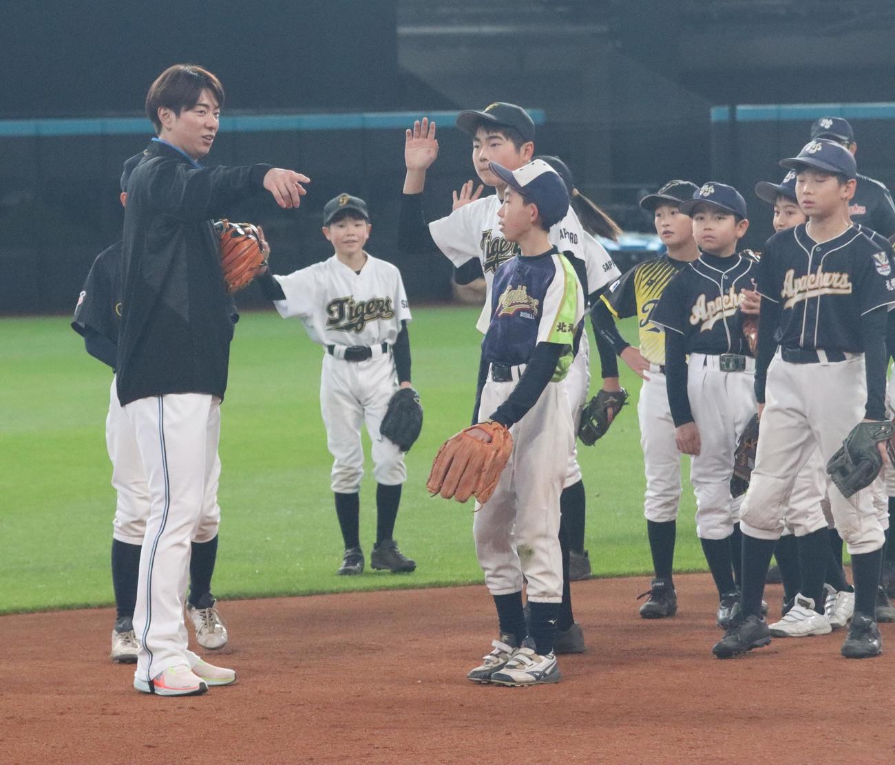 エスコンフィールドで行われた野球教室で子どもたちを指導する日本ハム松本剛（左）（撮影・永野高輔）