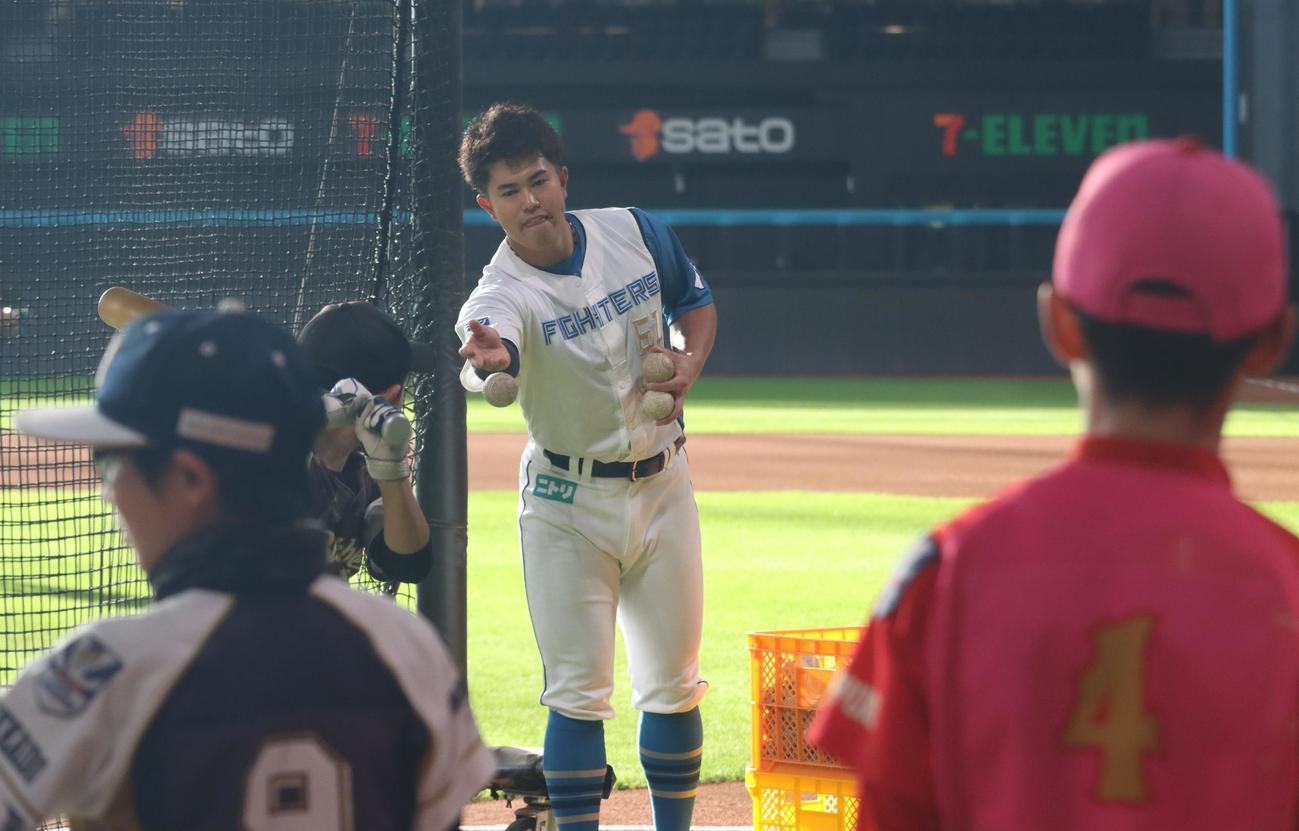 エスコンフィールドで行われた野球教室で子どもたちのトス打撃を手伝う日本ハム今川（撮影・永野高輔）