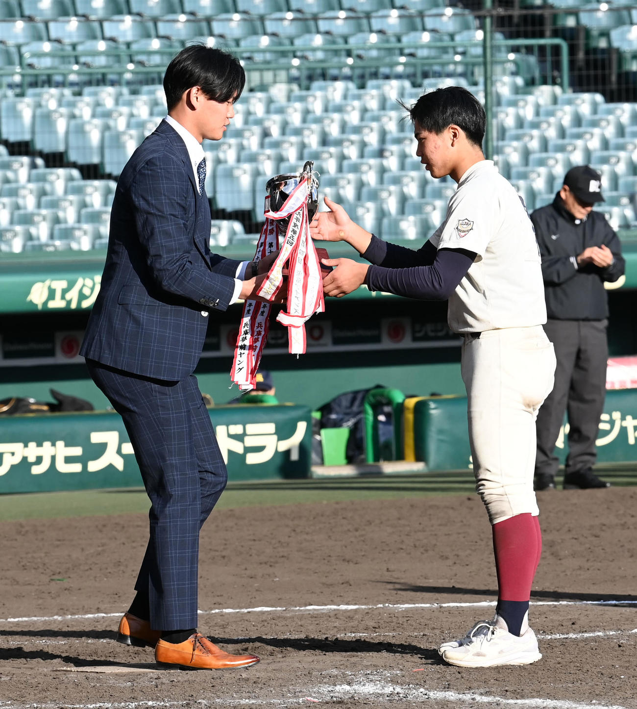 タイガースカップ表彰式で北摂ナインと優勝カップを手渡す阪神及川（撮影・前岡正明）