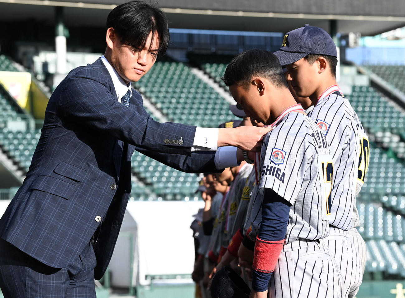 タイガースカップ表彰式で準優勝の湖南ナインにメダルを授与する阪神及川（撮影・前岡正明）
