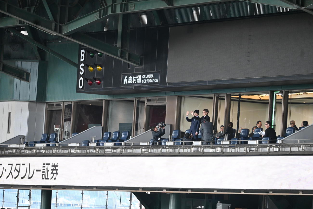 阪神甲子園球場での記念対局前に貴賓室のテラス席に登場し、手を振る日本将棋連盟会長の羽生善治九段（右）藤井聡太7冠（撮影・松浦隆司）