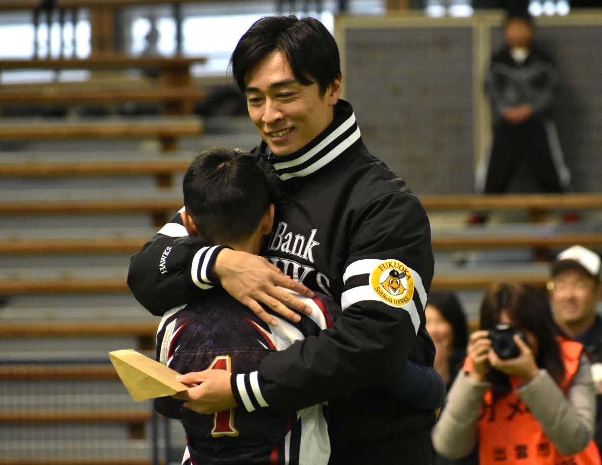 表彰式で野球少年とハグする和田氏（撮影・只松憲）