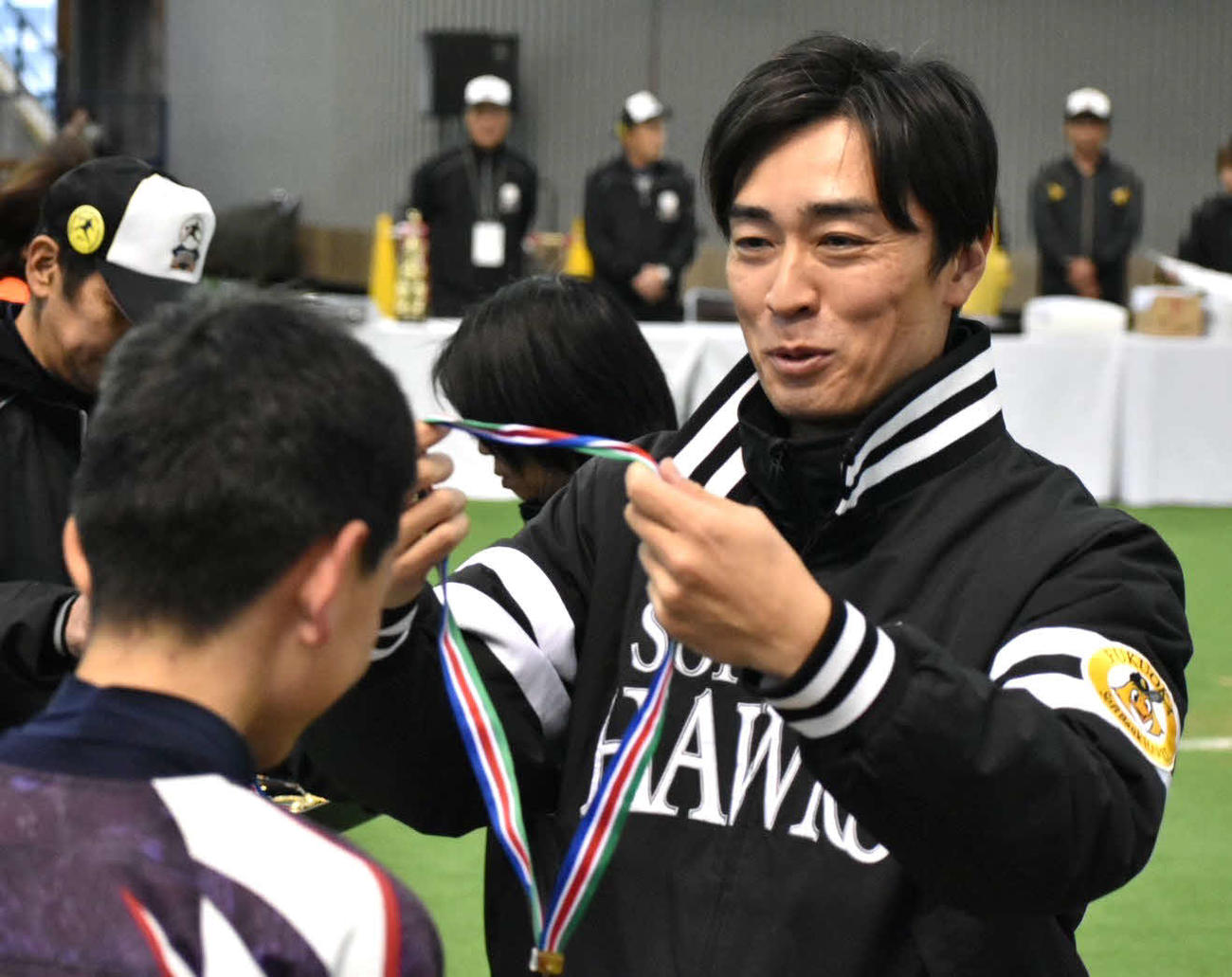 表彰式で優勝チームにメダルをかける和田氏（撮影・只松憲）