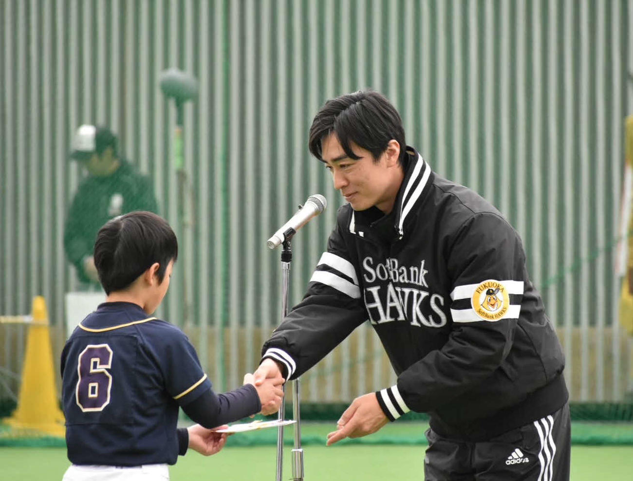 表彰式で野球少年と握手を交わす和田氏（撮影・只松憲）
