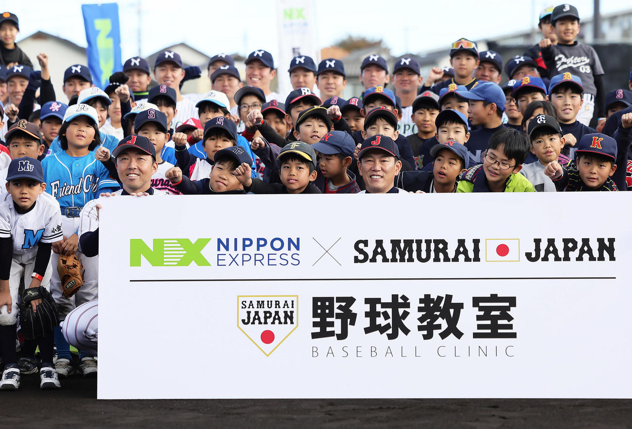 野球教室を前に、子どもたちと記念撮影する侍ジャパンの井端監督（右）と吉見コーチ（左）（撮影・足立雅史）