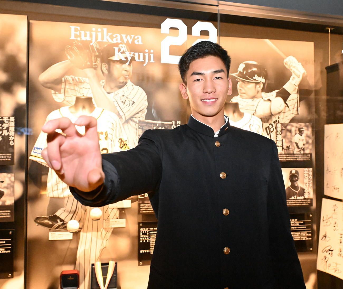甲子園歴史館を見学し、藤川監督の展示の前でポーズを取る阪神ドラフト2位今朝丸（撮影・和賀正仁）