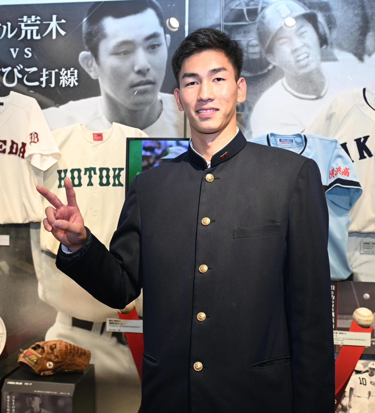 甲子園歴史館を見学し、母校報徳学園の前でポーズを取るドラフト2位の阪神今朝丸（撮影・和賀正仁）