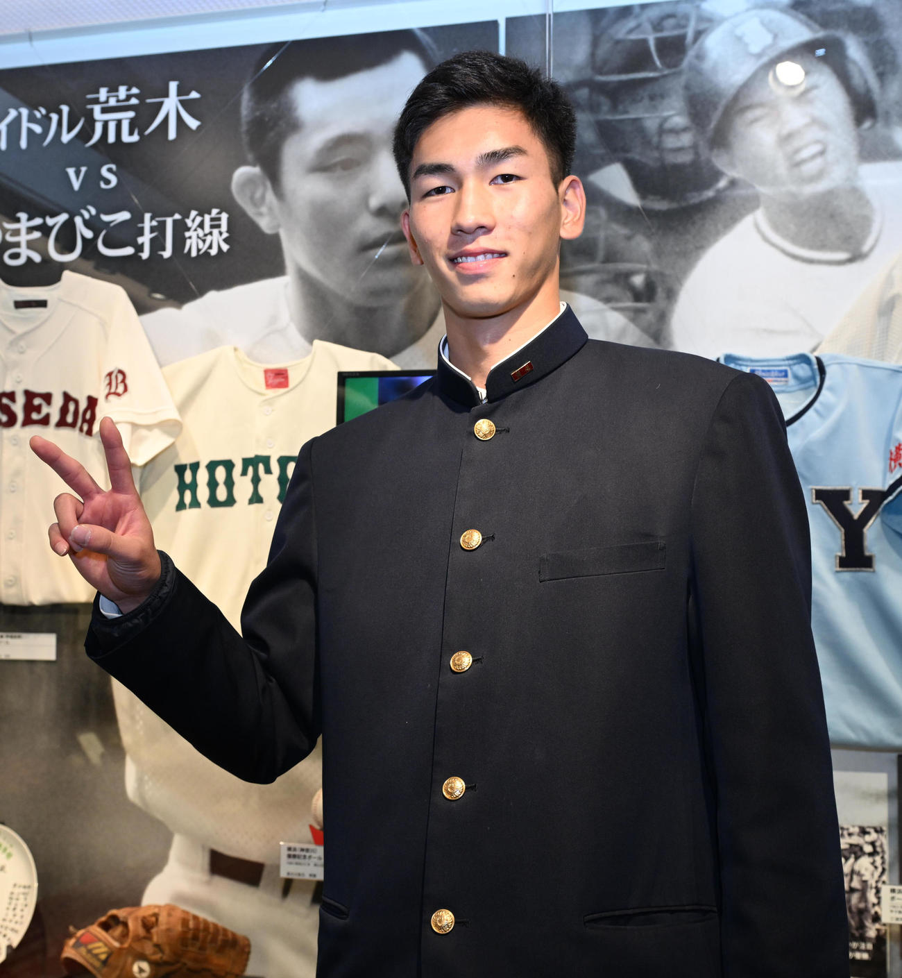 甲子園歴史館を見学し、母校報徳学園の前でポーズを取るドラフト2位の阪神今朝丸（撮影・和賀正仁）
