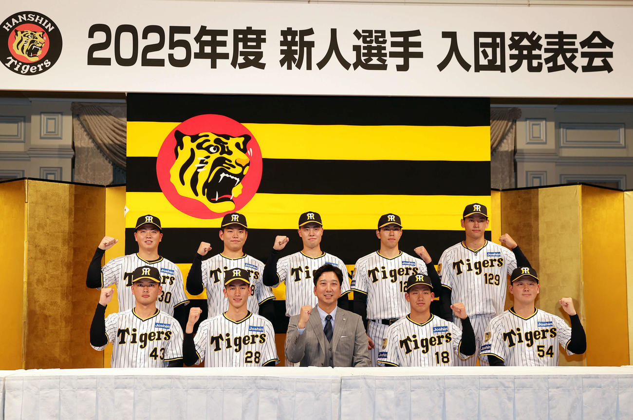 藤川監督（前列中央）を中心にガッツポーズで写真に納まる阪神の新人選手たち。前列左から町田、今朝丸、1人おいて伊原、木下、後列左から川崎、嶋村、佐野、工藤、早川（撮影・前田充）