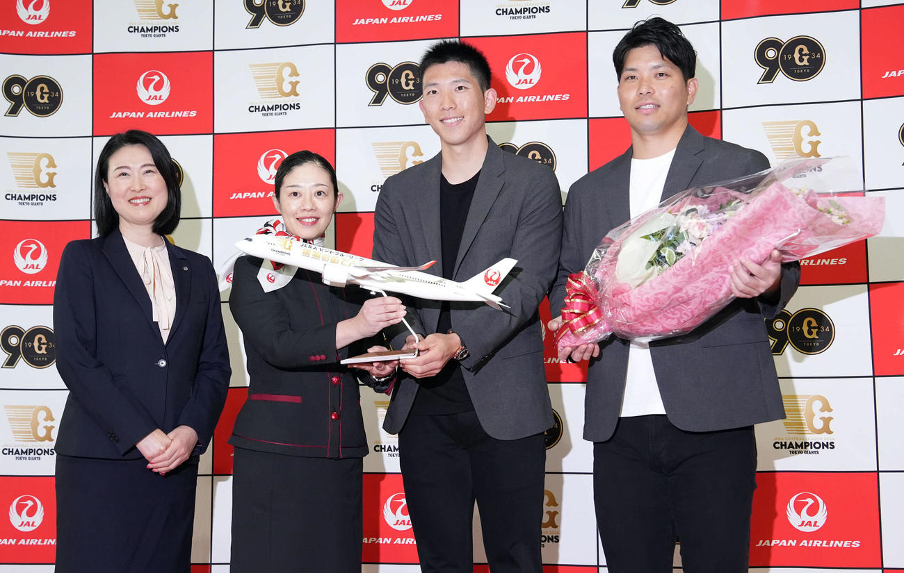 JAL職員から花束と記念品を贈られ笑顔を見せる、右から巨人大城卓と戸郷（撮影・たえ見朱実）