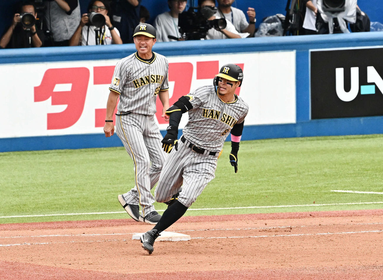 ヤクルト対阪神　8回表阪神無死、佐藤輝明（手前）は右翼に二塁打を放ち一塁を回る＝2024年6月30日　
