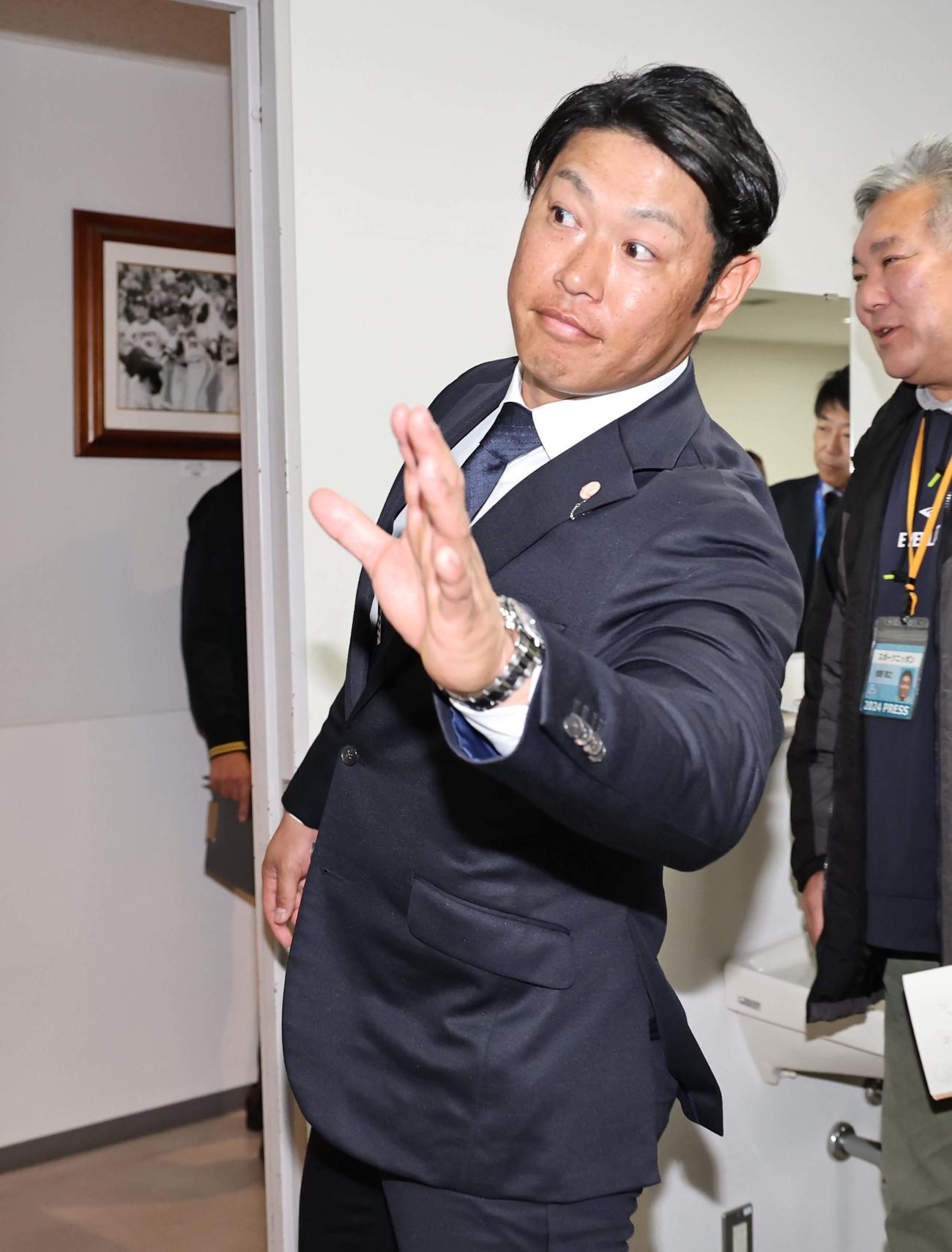 阪神残留会見を見に来た秋山にあいさつをして会見場を引き揚げる原口（撮影・上田博志）