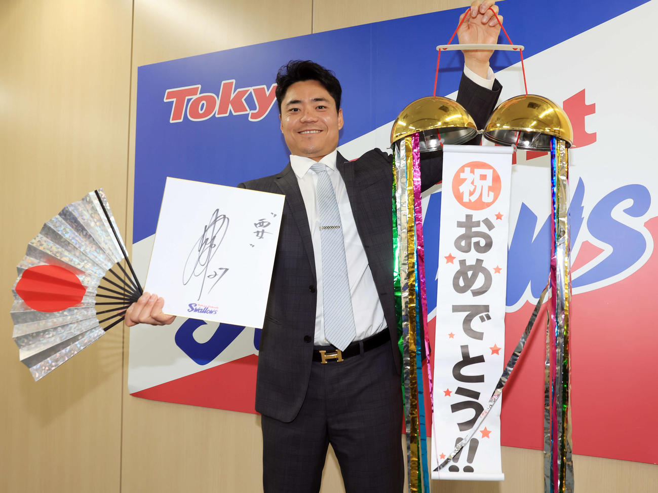 アップで契約更改を終え、くす玉を手に笑顔でポーズを決めるヤクルト中村（撮影・浅見桂子）