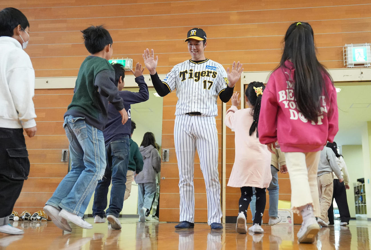 潮田小学校の子どもたちとハイタッチする阪神青柳（撮影・鈴木みどり）