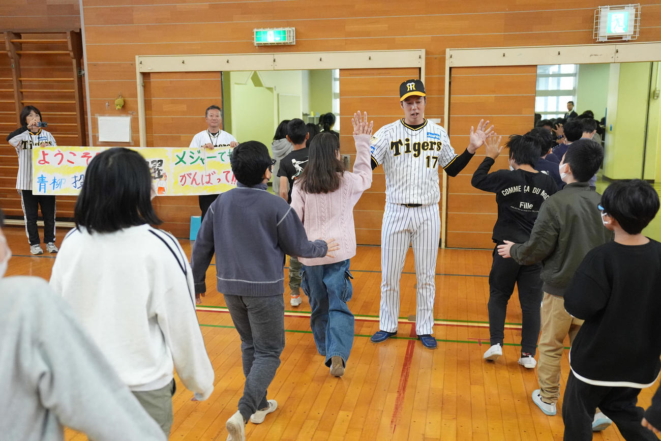 潮田小学校で子供たちとハイタッチする阪神青柳（撮影・鈴木みどり）