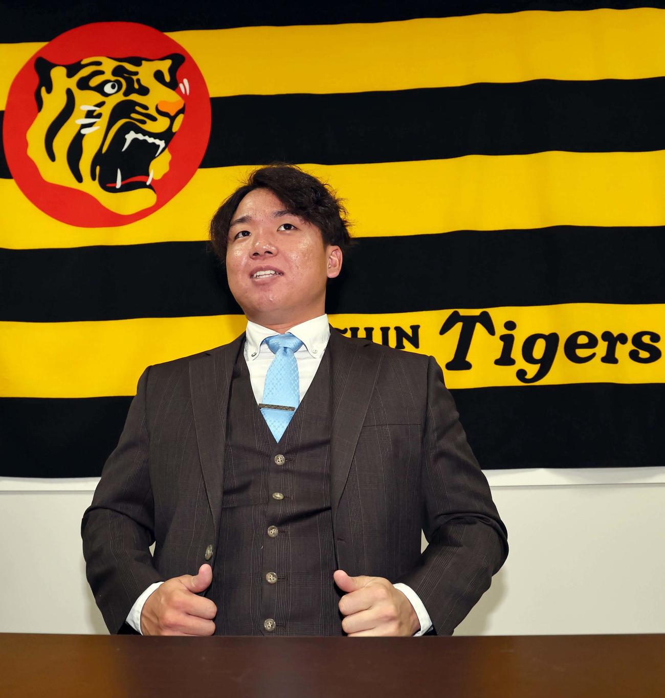 1300万円アップで更改を終え、笑顔を見せる阪神村上（撮影・上田博志）