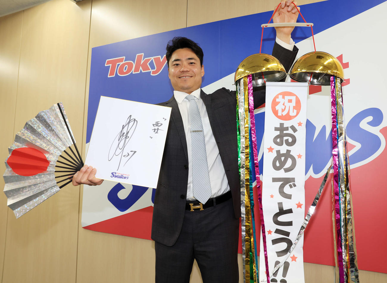 アップで契約更改を終え、くす玉を手に笑顔でポーズを決めるヤクルト中村（撮影・浅見桂子）