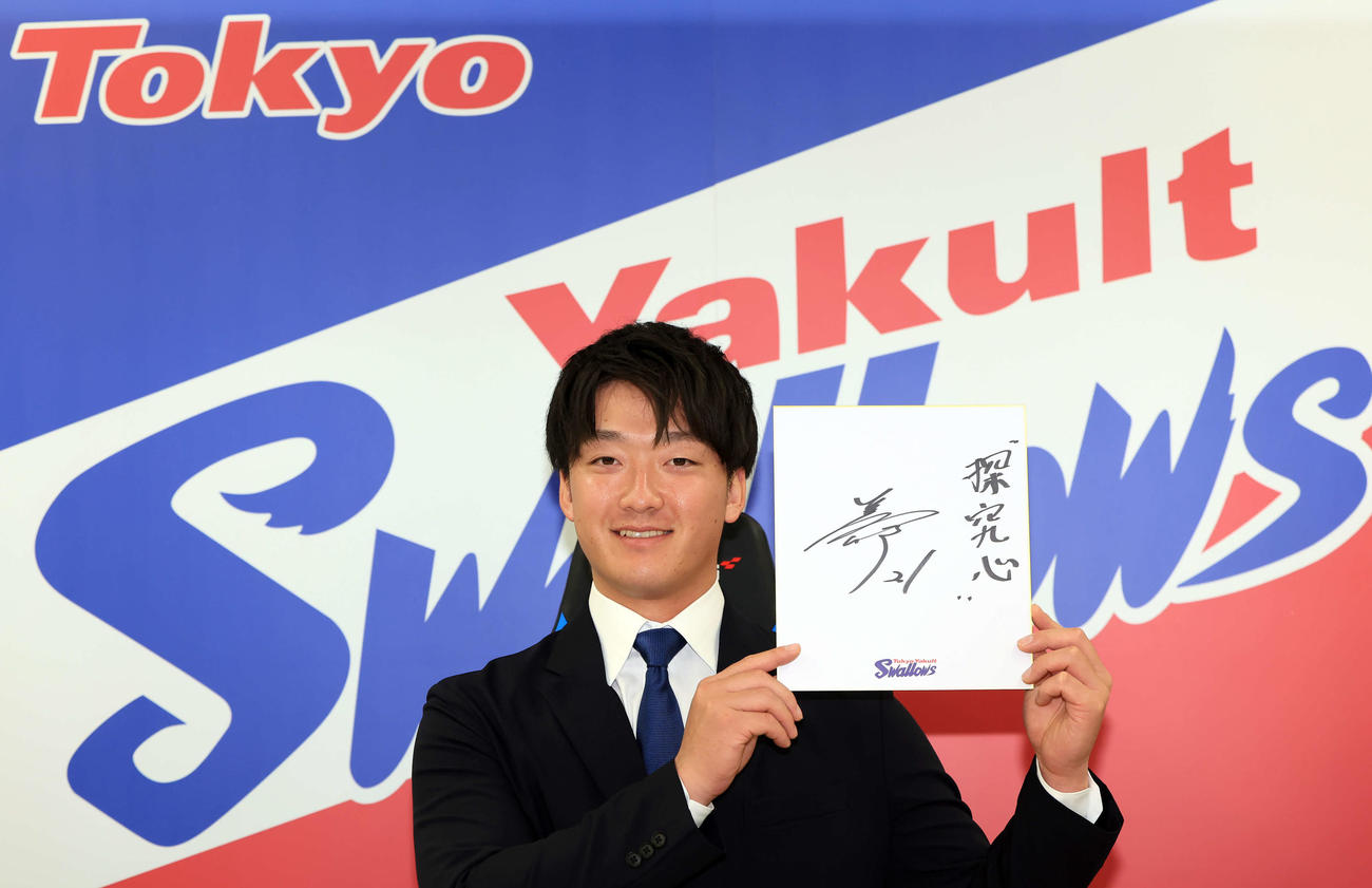 大幅アップで契約更改を終え、「探求心」と書いた色紙を手に笑顔のヤクルト吉村（撮影・浅見桂子）