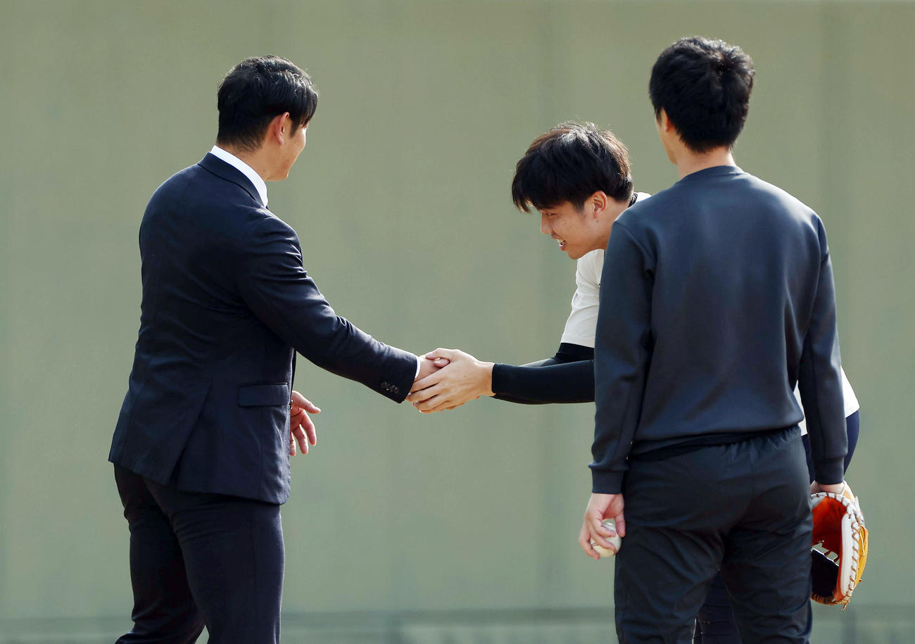 鳴尾浜球場に姿を見せた阪神原口（左）と握手を交わす才木（撮影・前田充）