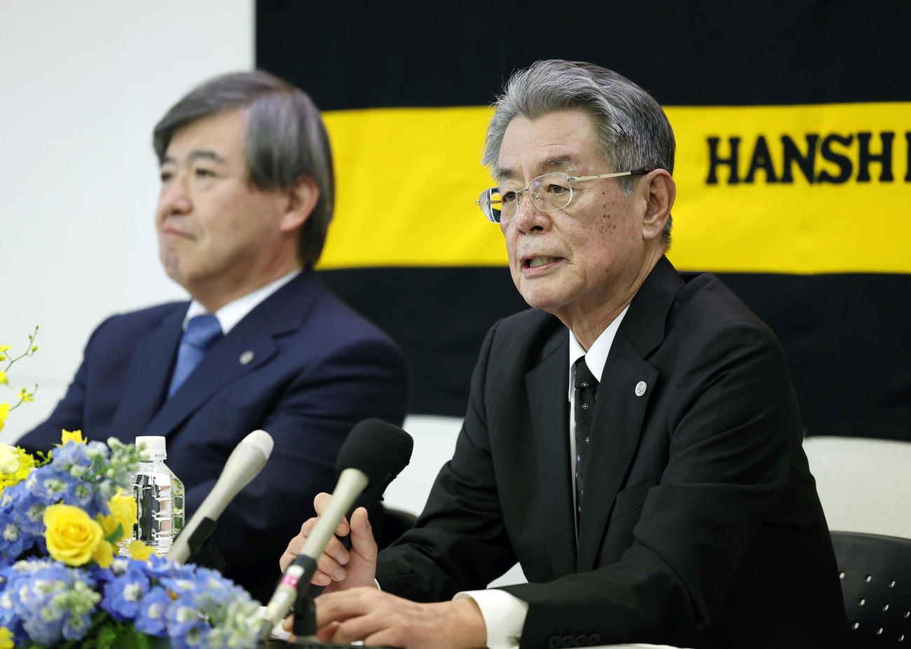 オーナー交代記者会見に臨む阪神秦次期オーナー。左は杉山オーナー（撮影・前田充）