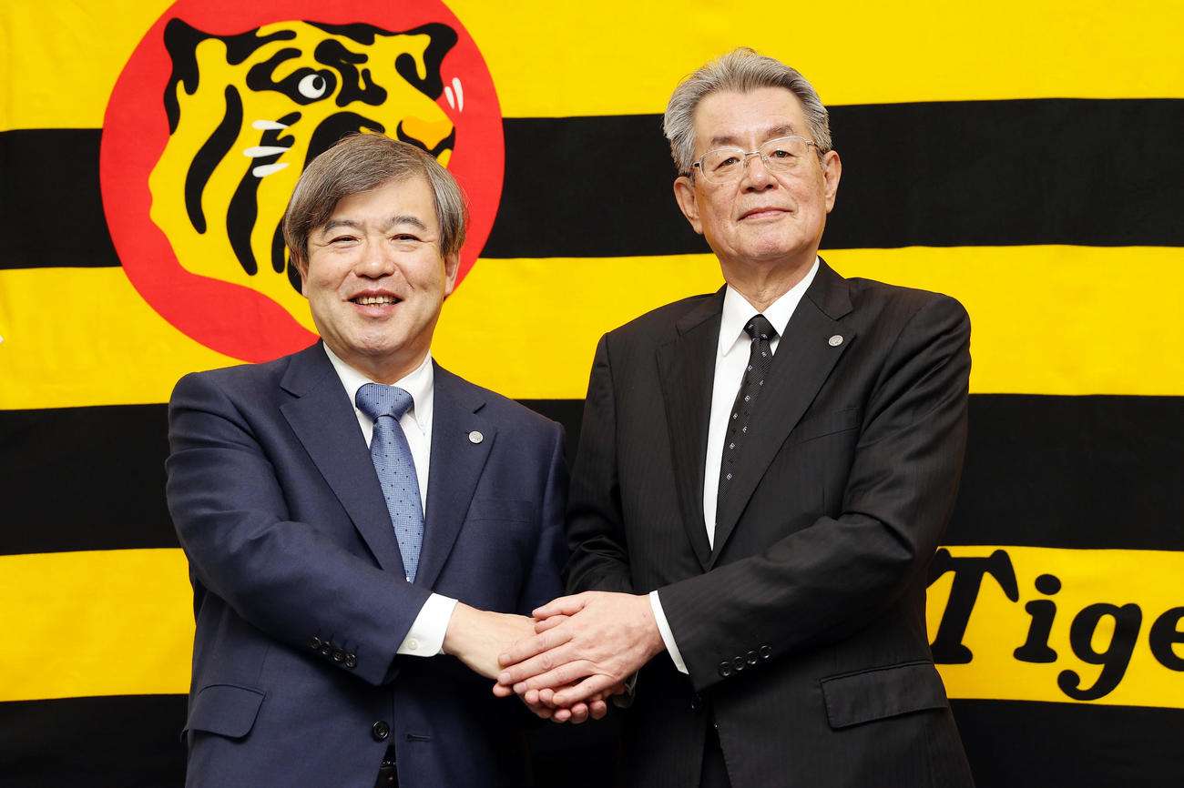 オーナー交代記者会見を終え握手を交わす阪神杉山オーナー（左）と秦次期オーナー（撮影・前田充）