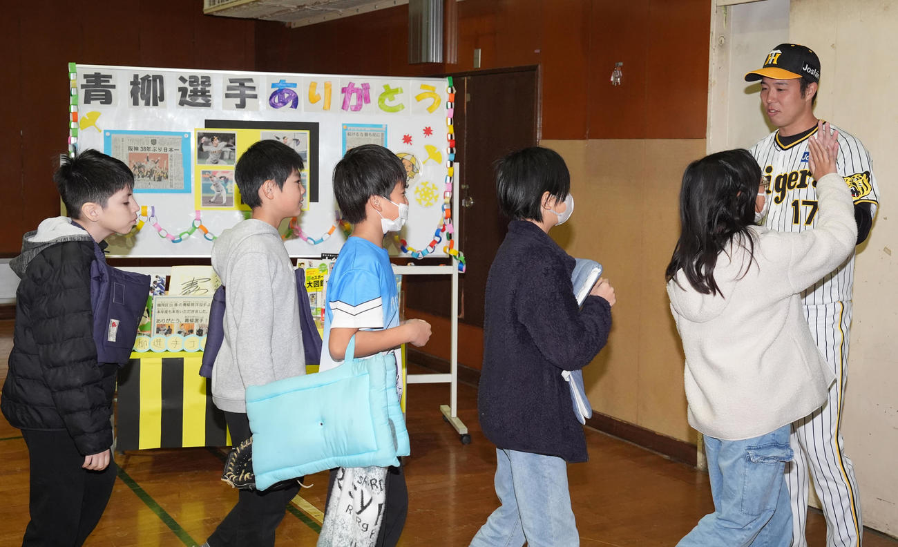 汐入小学校の子どもたちとハイタッチする阪神青柳（撮影・鈴木みどり）