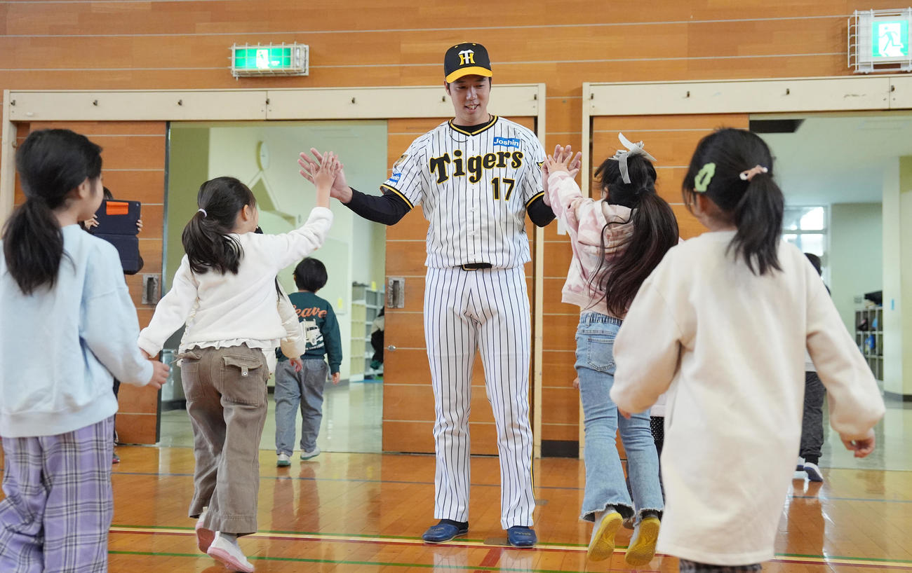 塩田小学校の子どもたちとハイタッチする阪神青柳（撮影・鈴木みどり）
