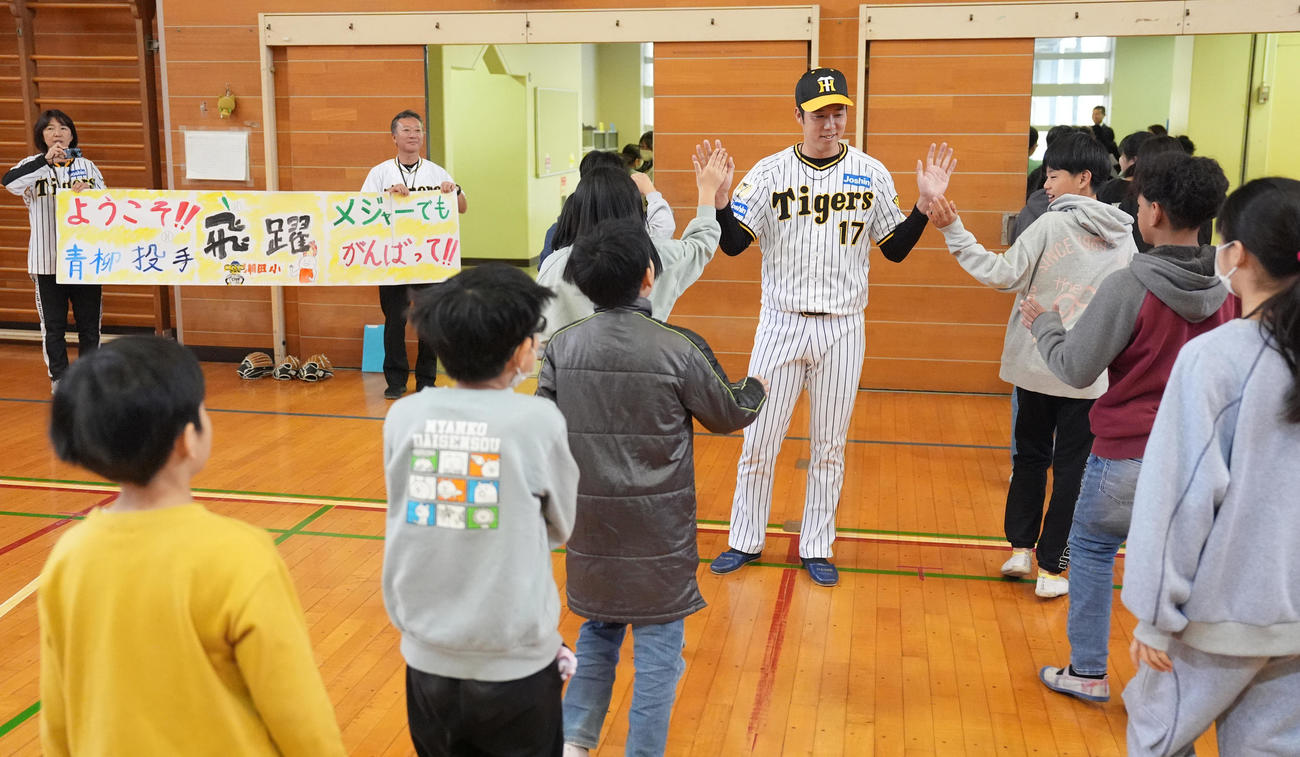 潮田小学校の子どもたちとハイタッチする阪神青柳（撮影・鈴木みどり）