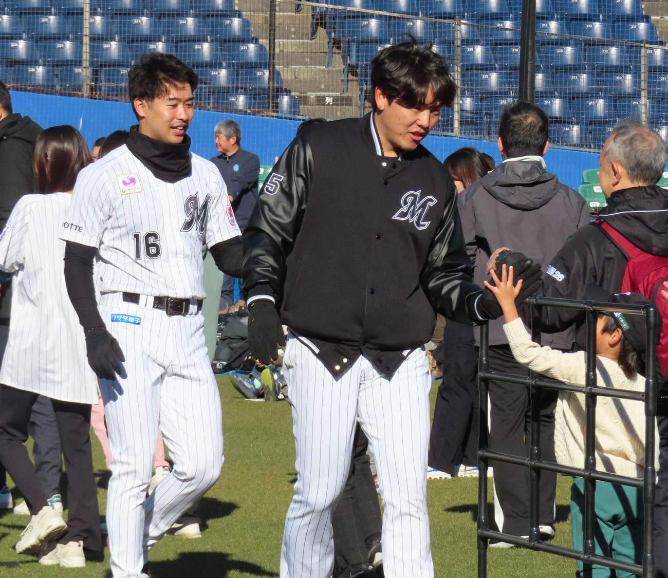 「千葉ロッテマリーンズの選手と走ろう！！」イベントに参加し、ファンとハイタッチするロッテ安田。後方は種市（撮影・水谷京裕）