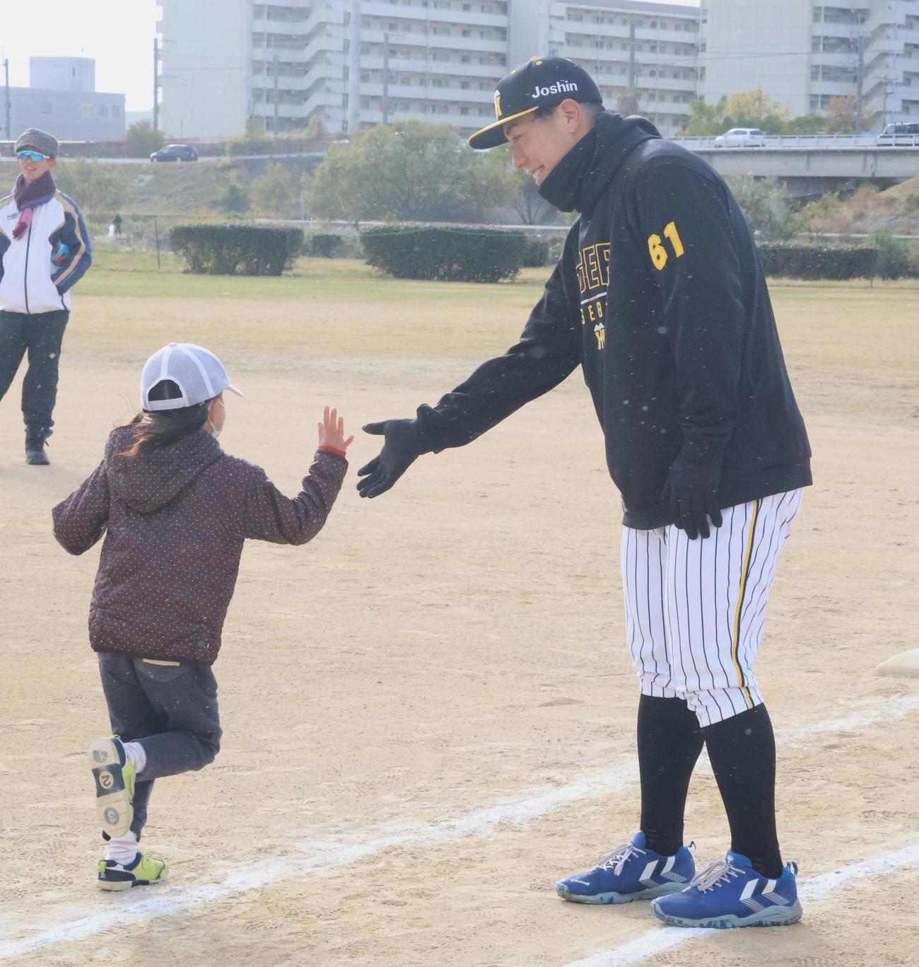 ベースランニングを行う子どもとハイタッチする阪神豊田（撮影・塚本光）