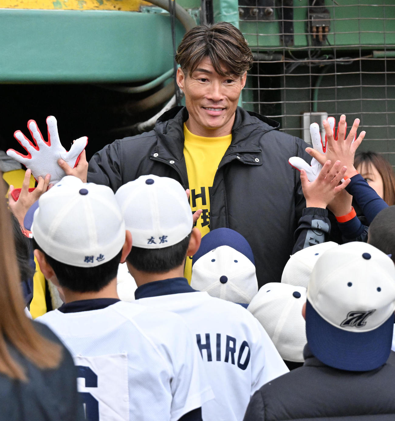 子どもたちとハイタッチをする糸井SA（撮影・石井愛子）