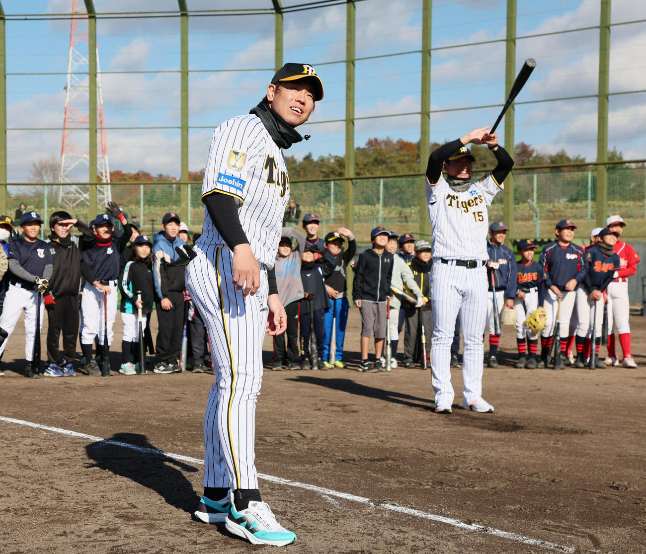 野球教室に参加し西純のティー打撃でトスを出す梅野（左）はボールの行方を見守る（撮影・加藤哉）